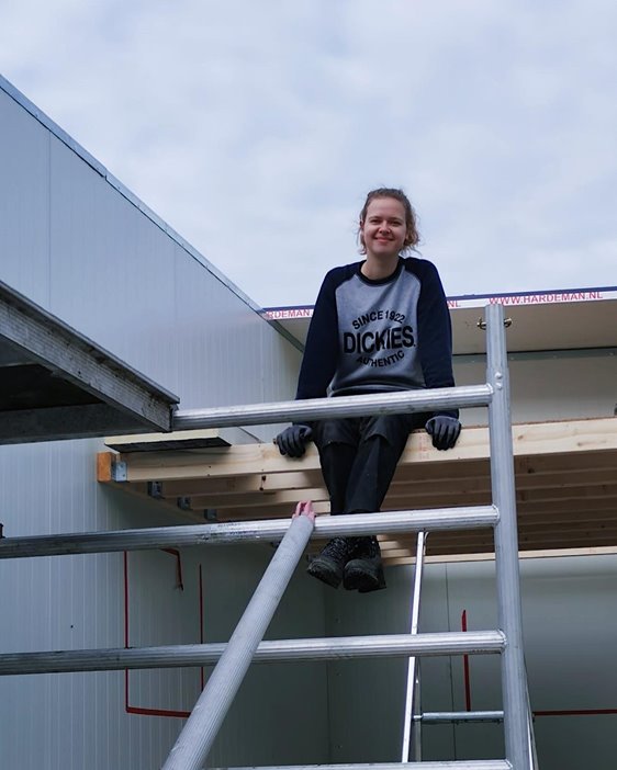 Femke zittend op tiny house
